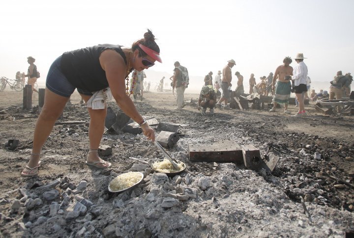 Rhonda Clark cooks hash browns for breakfast on the burned remains of the Man.  ©REUTERS