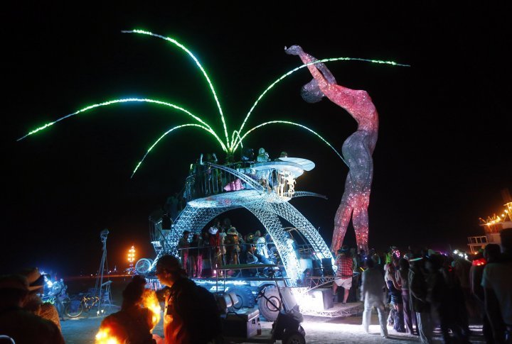 Participants dance around and atop an art car parked beside the "Truth is Beauty" sculpture. ©REUTERS