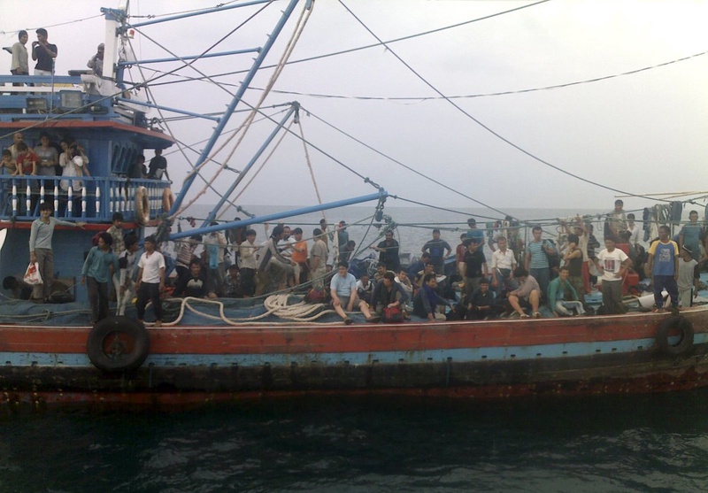 Asylum seekers sit on a fisherman's boat. ©REUTERS