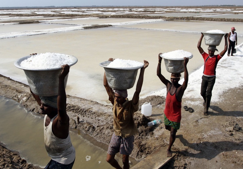 Workers carry salt to load it in a supply truck. ©REUTERS