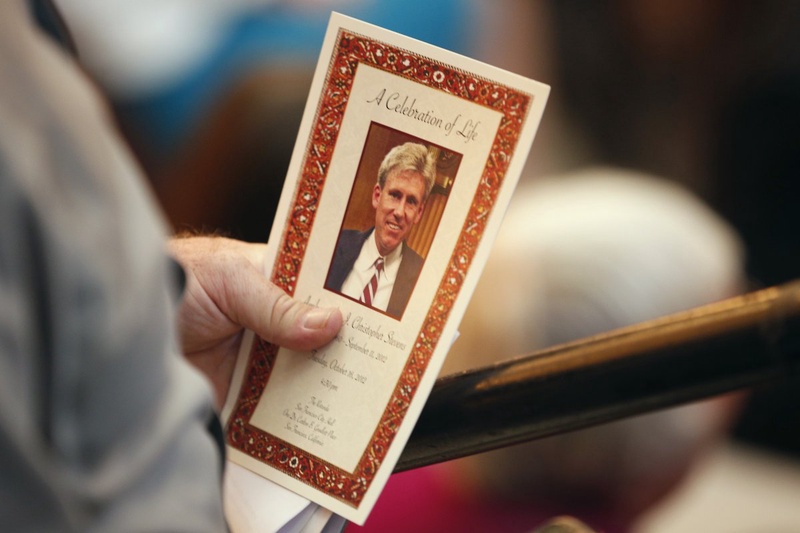 A mourner holds a program during a public memorial service for slain U.S. Ambassador to Libya Christopher Stevens. ©REUTERS