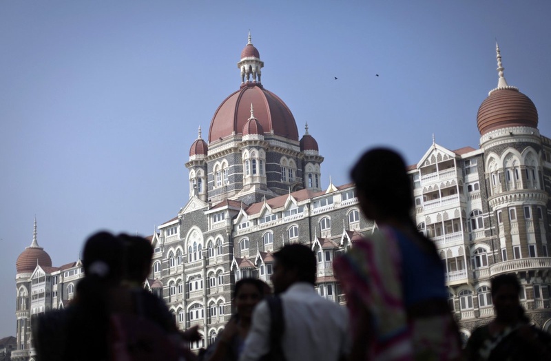 Tourists are silhouetted against the backdrop of the Taj Mahal hotel. ©REUTERS