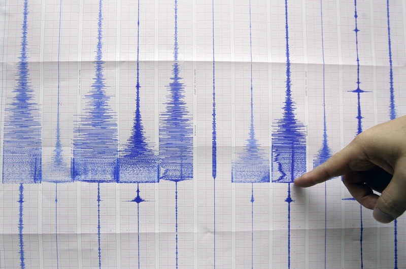 A seismologist points at a graphic showing an earthquake reading. ©REUTERS