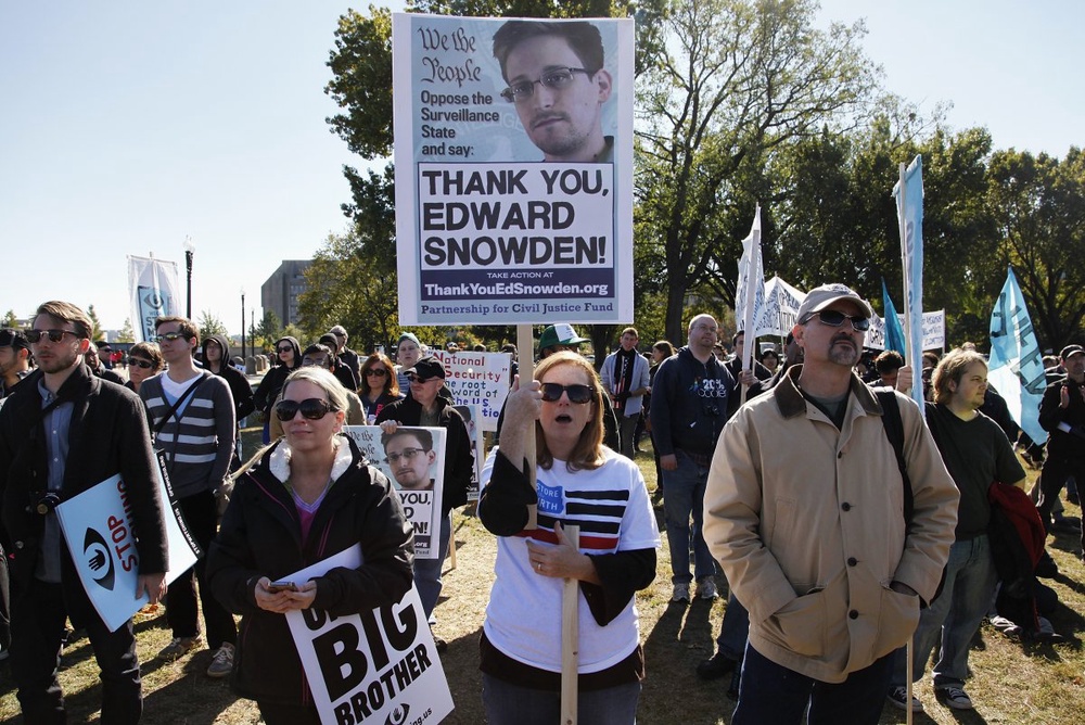 Demonstrators hold signs supporting fugitive former NSA contractor Edward Snowden. ©Reuters/Jonathan Ernst