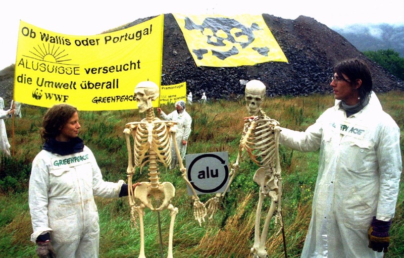 Two members of the environmentalist organisation "Greenpeace" stand next to skeletons as they, along with about 30 other environmentalists, protest against pollution. ©Reuters/STR New