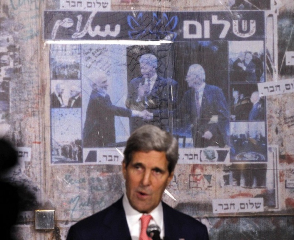  U.S. Secretary of State John Kerry is pictured in front of a photo showing U.S. President Bill Clinon, Jordan's King Hussein and Yitzhak Rabin, as Kerry marks the 18th anniversary of Rabin's assassin