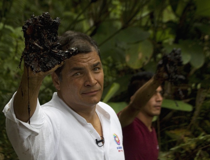 Ecuador's President Rafael Correa raises an oil-coated hand to show media, near petroleum debris, said to be caused by Chevron-Texaco. ©Reuters/Guillermo Granja