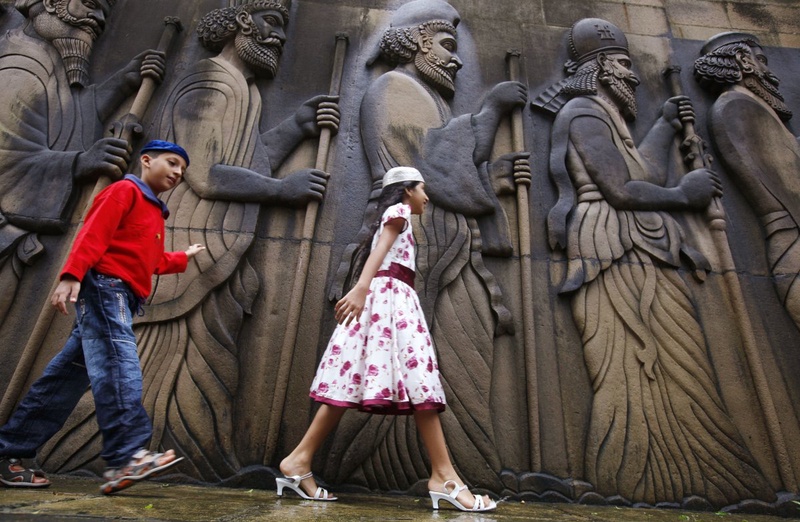 Parsi children touch the walls of a Parsi fire temple featuring life-size carvings of ancient priests during the Parsi New Year day in Mumbai. ©Reuters/Danish Siddiqui 