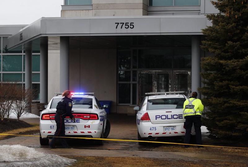 Police officers wait outside with their guns drawn after a shooting inside the A. Grenville and William Davis Courthouse. ©Reuters/Mark Blinch 