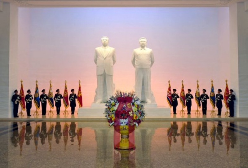 A floral basket from Kim Jong Un in front of statues of his grandfather Kim Il Sung and father Kim Jong Il at Ku’msusan. Photo courtesy of nkleadershipwatch.wordpress.com