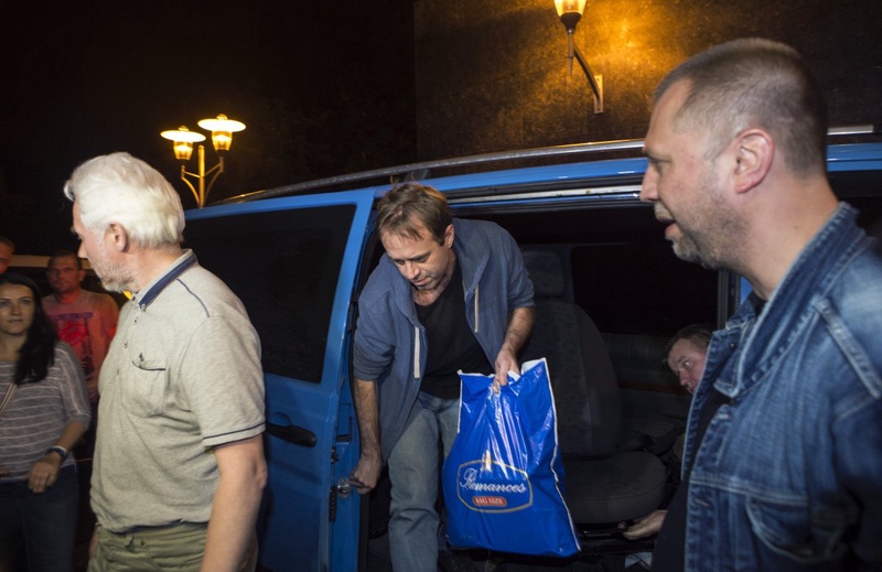 Unidentified members of OSCE Special Monitoring Mission in Ukraine get out of a vehicle next to Alexander Borodai (R), Prime Minister of the self proclaimed "Donetsk People's Republic". ©Reuters/Shami